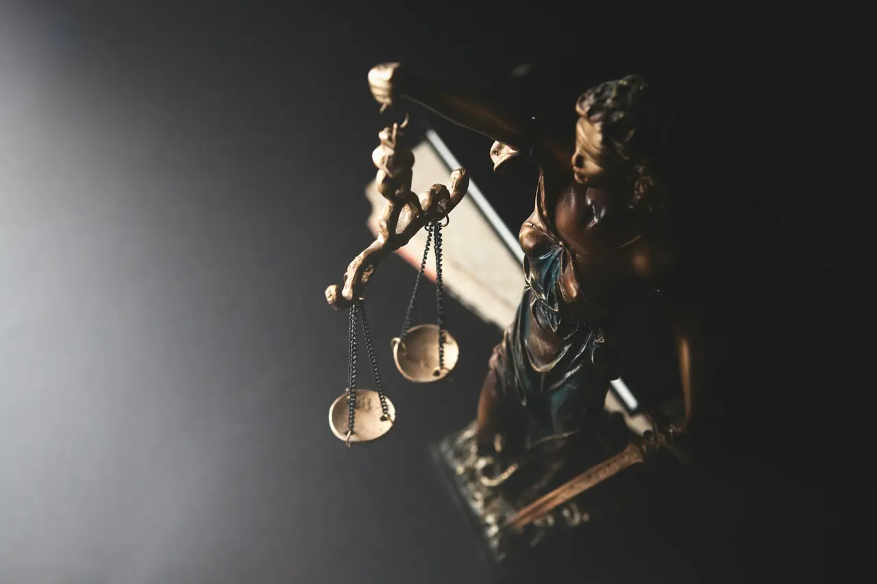 Statue of Lady Justice with scales on a dark background